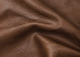 A close-up of draped brown Aged Maple leather showing its natural grain and texture.