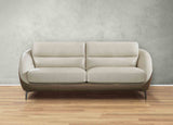 Beige sofa on a wooden floor with a gray wall background