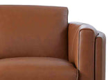 Close-up of a brown leather armchair with a white cushion.