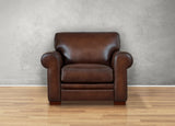 Brown leather armchair on a wooden floor with a gray wall background