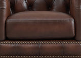 Close-up of a brown leather armchair with studded details