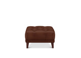 A brown tufted leather ottoman with dark wooden legs, shown from the front on a solid white background.