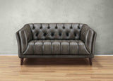 Brown leather sofa on a wooden floor with a gray wall background