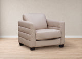A modern beige armchair with padded cushions and dark wooden legs, set against a neutral beige wall and light wood floor.