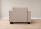 A light beige leather armchair shown from the back, positioned on a light wood floor against a neutral beige wall.