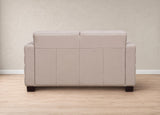 A light beige upholstered loveseat or sofa shown from the back, set against a neutral beige wall and light wood floor.