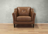 Brown leather armchair against a gray wall on a wooden floor