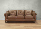 Brown leather sofa against a gray wall on a wooden floor