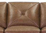Close-up of a brown leather sofa with diamond pattern stitching.