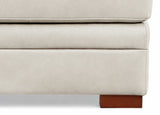 Close-up of a beige upholstered piece of furniture with wooden legs on a white background