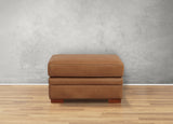 Brown leather ottoman on a wooden floor with a gray wall background