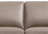 Close-up of a beige leather sofa with a plain background