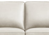 Close-up of a beige sofa with a plain background