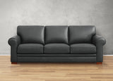 Gray leather sofa on a wooden floor with a gray wall background