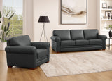 Gray sofa and armchair set in a living room with a lamp and artwork on the wall.