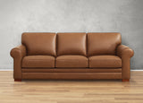 Brown leather sofa on a wooden floor with a gray wall background
