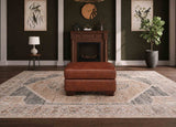 Brown leather ottoman on a patterned rug in a room with a fireplace and decorative elements.