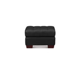 A modern black tufted leather ottoman with dark reddish-brown wooden block feet, shown from a front-facing perspective on a solid white background.