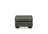 A modern gray upholstered ottoman with a tufted square backrest and dark brown wooden feet, shown against a plain white background.