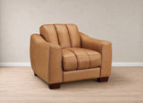 A tan leather armchair with a tufted backrest and seat, shown in a minimalist room setting with a textured beige wall and light wood floor.