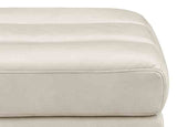 Close-up of a beige leather ottoman with visible stitching on a white background
