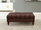 Brown leather ottoman in a room with a gray wall and white floor.