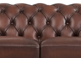 Close-up of a brown leather sofa with tufted backrest