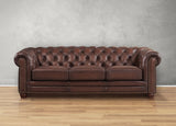 Brown leather sofa with tufted backrest on a wooden floor and gray wall background