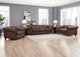 Brown leather sofa set in a living room with gray walls and large windows.