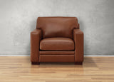 Brown leather armchair on a wooden floor with a gray wall background