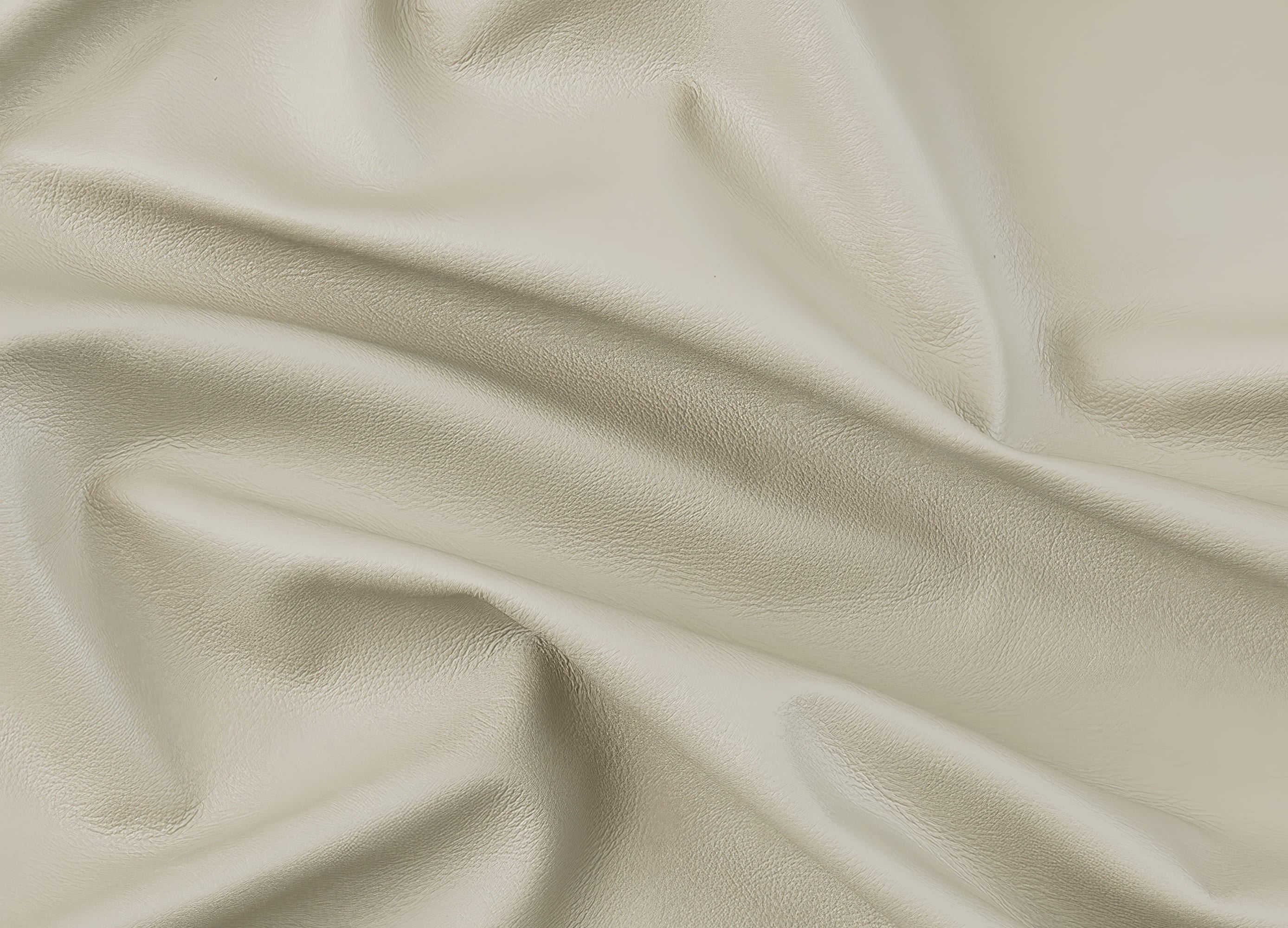 A close-up of draped light beige leather fabric with soft folds and a smooth texture.