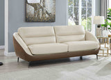 Beige sofa in a living room with a painting and lamp in the background