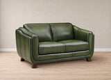An olive green leather loveseat sofa with dark wood legs, shown in a studio setting with a textured beige wall and light wood floor.