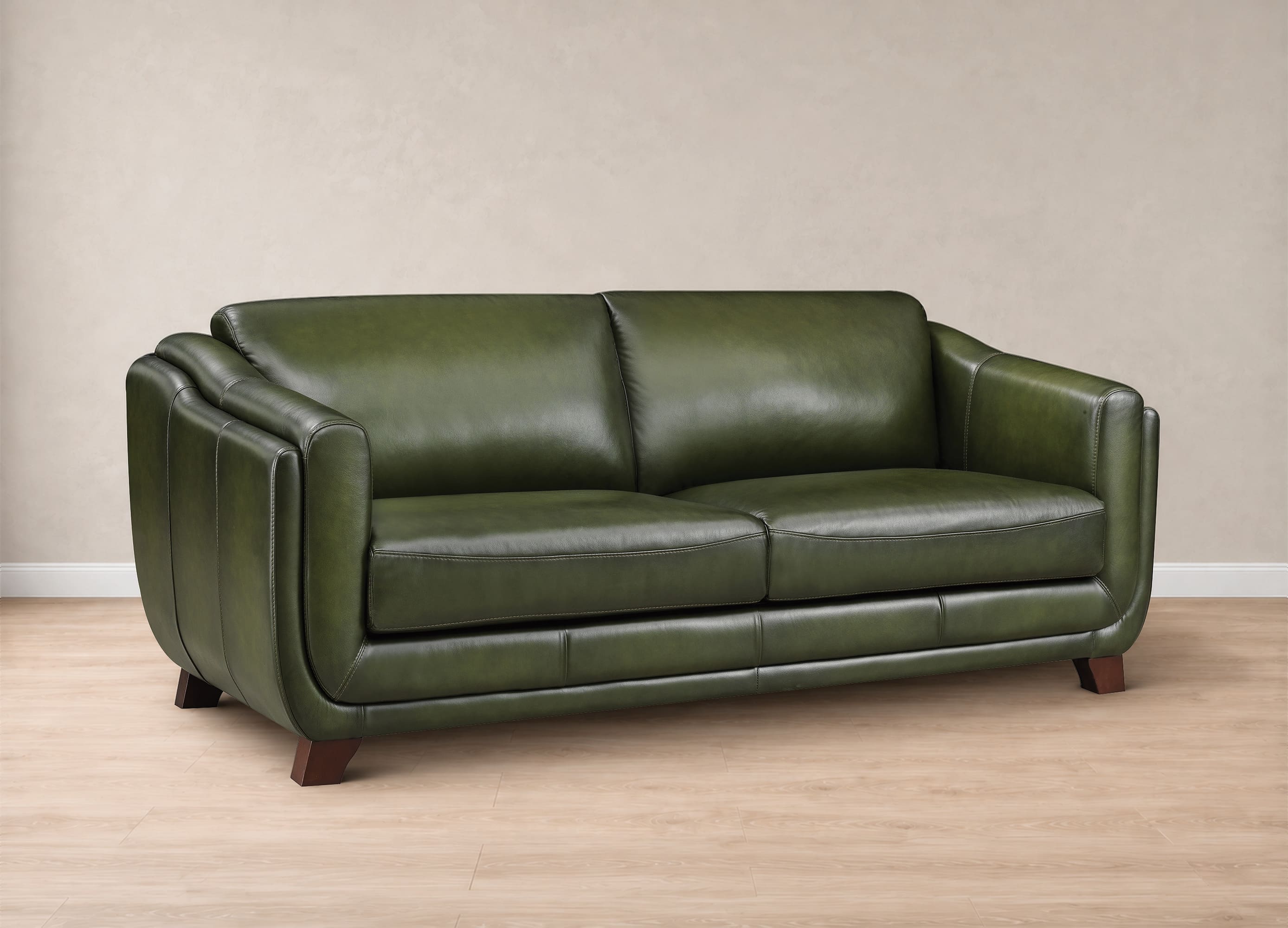 An olive green leather loveseat sofa with dark wood legs, shown in a studio setting with a beige textured wall and light wood floor.