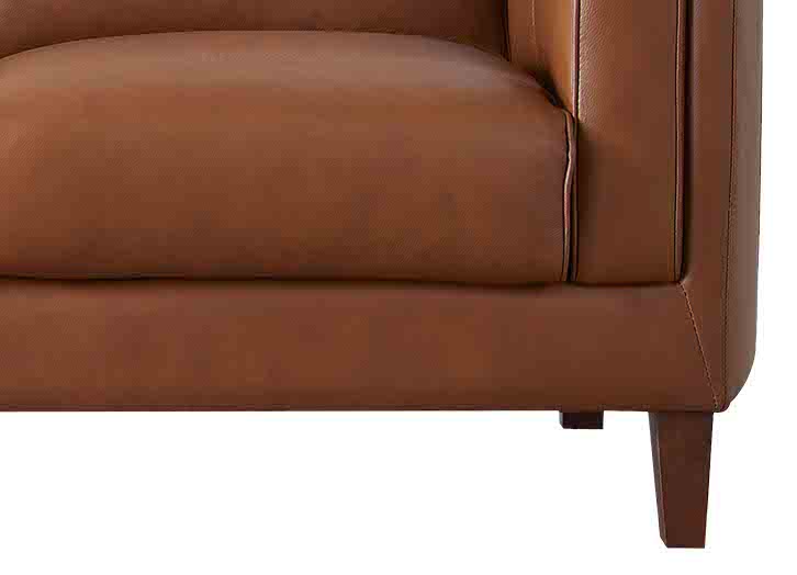 Close-up of a brown leather sofa corner on a white background