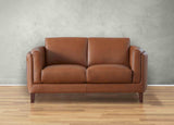 Brown leather sofa on a wooden floor with a gray wall background