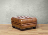 Brown leather ottoman on a wooden floor with a gray wall background
