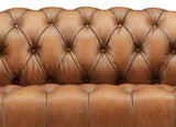 Brown leather sofa with tufted backrest on a white background