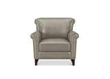 A classic wingback armchair upholstered in light taupe leather with dark brown wooden legs and silver nailhead trim, shown against a plain white background.