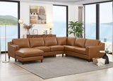 A tan leather sectional sofa with a chaise lounge is shown in a modern living room setting with large windows overlooking the ocean, a gray area rug, and a side table.
