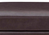 Close-up of a brown leather sofa with visible stitching.