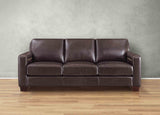 Brown leather sofa against a gray wall on a wooden floor