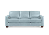 A three-seat sofa upholstered in light blue leather, featuring square arms, dark brown wooden legs, and subtle gold accent stitching on the armrests, shown against a plain white background.