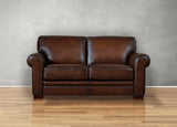Brown leather sofa on a wooden floor with a gray wall background