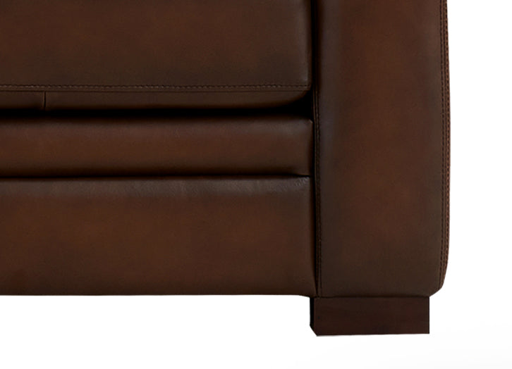 Close-up of a brown leather sofa corner on a white background