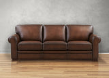 Brown leather sofa on a wooden floor with a gray wall background