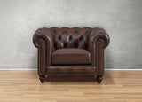 Brown leather armchair against a gray wall on a wooden floor