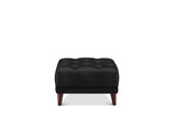 A black tufted leather ottoman with dark brown wooden legs, shown from the front on a solid white background.
