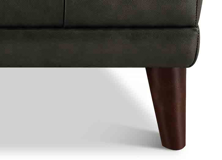 Close-up of a brown leather sofa with wooden legs on a white background