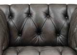 Close-up of a brown leather sofa with tufted backrest